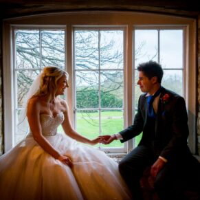 Bride and groom in window at Notley Tythe Barn wedding