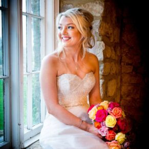 Bride with window lighting at Notley Tythe Barn wedding