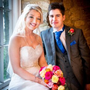 Portrait of bride and groom with window lighting at Notley Tythe Barn wedding