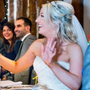 Bride reacting to speeches at Notley Tythe Barn wedding
