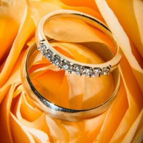Wedding rings on a yellow rose at Notley Tythe Barn wedding