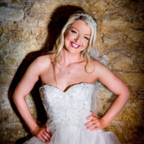 Bride against rustic stone wall at Notley Tythe Barn wedding