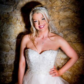 Bride against rustic stone wall at Notley Tythe Barn wedding