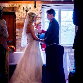 Bride and groom silhouetted against window at Notley Tythe Barn wedding