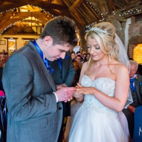 Groom admiring bride's wedding ring at Notley Tythe Barn wedding