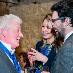 Groom chatting with guest at Notley Tythe Barn wedding