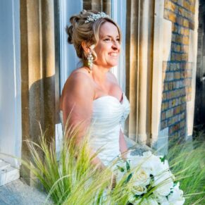 Oakley Court wedding photography of the bride through the grasses at the hotel entrance