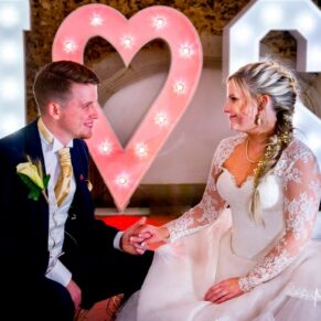 Missenden Abbey autumn wedding pose of the newlyweds with their illuminated giant letters