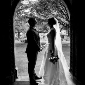 Wedding at St Mary's Church Thame - silhouette shot of the newlyweds in the doorway