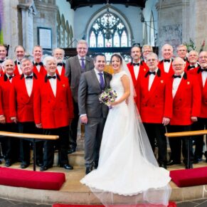 Wedding at St Mary's Church Thame - the newlyweds pose for the camera with the London Welsh Male Voice Choir