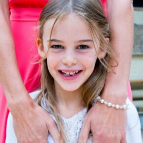 Waddesdon wedding photography of this young guest being hugged by her mother