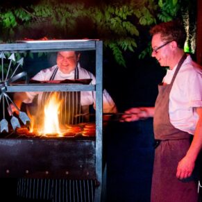 The staff prepare the food on the bbq in this Waddesdon wedding photography moment during the evening reception