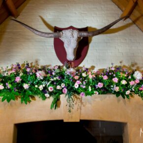 Waddesdon wedding photography of the floral arrangement above the fireplace in the West Hall