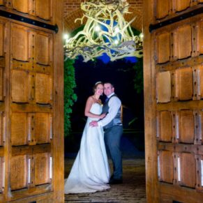 Waddesdon wedding photography of the newlyweds in the grand entrance doorway at dusk