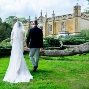 Missenden Abbey wedding shot of the newlyweds taking a stroll under the cedar tree