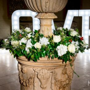 Waddesdon Dairy Christmas wedding flowers with the illuminated letters in the background