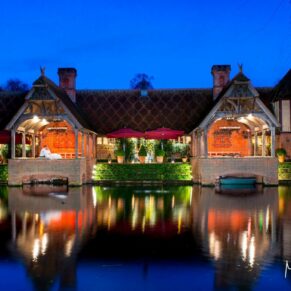 Dairy Waddesdon Christmas wedding image captured at dusk across the lake