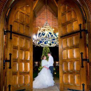 Dairy Waddesdon Christmas wedding pose shot through the entrance doors at dusk
