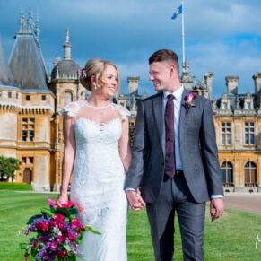 Waddesdon Manor photography shoot of the newlyweds walking on the lawn at the front of the house