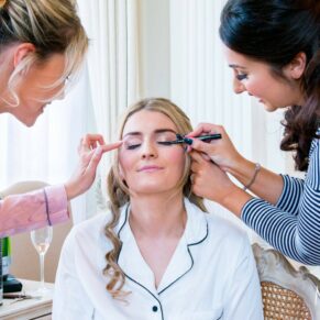 Hedsor House wedding photographs of the bride receiving her final touches of make-up