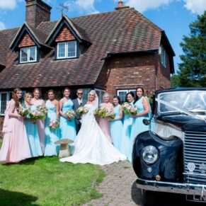 Bridesmaids, bride and vintage car at Notley Tythe Barn wedding