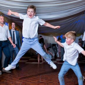 Star jumps on the dancefloor at Notley Tythe Barn wedding