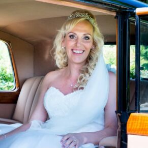 Bride arriving in vintage car at Notley Tythe Barn wedding