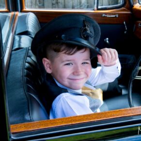 Cute little boy in vintage wedding car at Notley Tythe Barn wedding