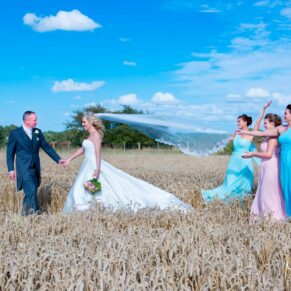 Notley Tythe Barn wedding photography - bride and groom and bridesmaids in a wheat field