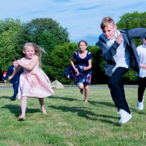 Notley Tythe Barn young wedding guests running through the grounds