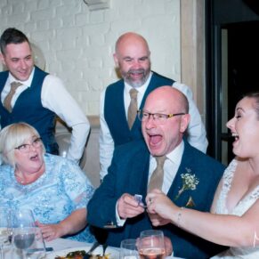 Waddesdon Dairy winter wedding photograph of the guest reactions to the magician's tricks