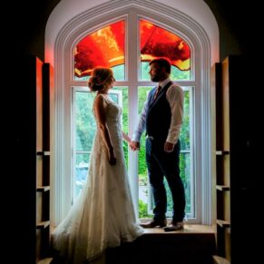 Classic wedding photography in Buckinghamshire - silhouette window image of the newlyweds at Missenden Abbey
