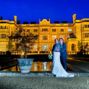 Newlyweds pose for a night-time shot at Eynsham Hall Christmas wedding