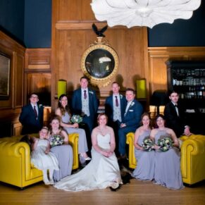 Group pose in the Gun Room at Eynsham Hall Christmas wedding