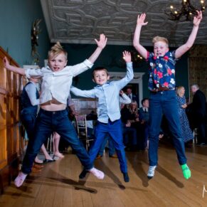Young boys jumping on the dancefloor at Eynsham Hall Christmas wedding