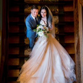 Eynsham Hall wedding photographs of newlyweds on staircase