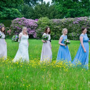Strolling through the buttercup meadow at Hampden House wedding
