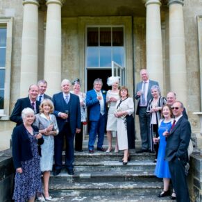 Group pose on the steps at Hartwell House Hotel wedding