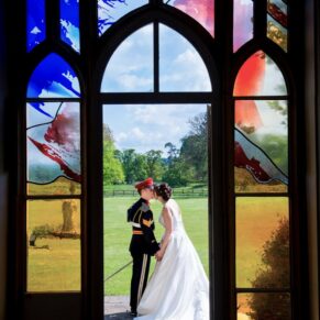 The newlyweds through the archway at Missenden Abbey military wedding
