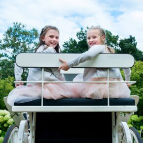 Photography of the flower girls enjoying their moment sat on top of the stunning carriage at this Sopwell House Hotel summer wedding