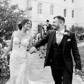 Photography of the smiling newlyweds taking a relaxed stroll through the gorgeous grounds at their Sopwell House wedding
