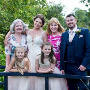 The bride and groom pose for a relaxed photography capture with a couple of their friends on the bridge at their Sopwell House wedding