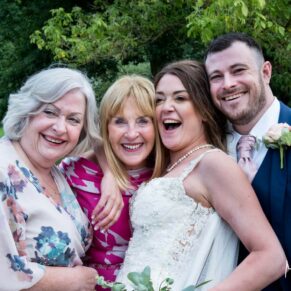 Photography of the newly married couple posing for a relaxed image with a couple of their friends in the gardens during their wedding drinks reception at Sopwell House