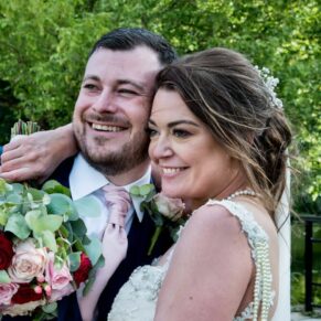 The newlyweds captured on the pretty bridge in the lush green gardens at Sopwell House