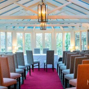 Photography of the indoor civil ceremony setup with views over the lovely gardens at the Bay Tree Hotel in Burford