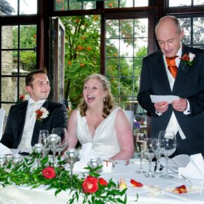 Lively wedding photography of the speeches in progress in the dining room at the Bay Tree Hotel in Burford