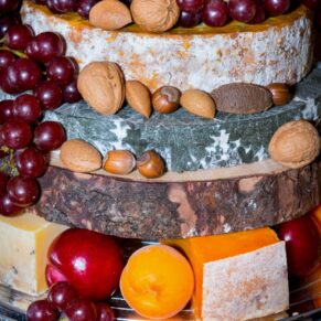 Yummy multi layered savoury cheese cake covered in fruit and nuts