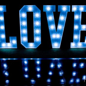 Photography of giant illuminated LOVE letters positioned on the dance-floor at this Bay Tree Hotel wedding in Burford