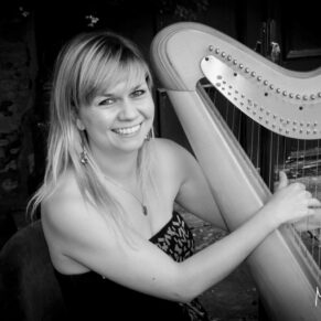 Photography of Harpist Tori Handsley as she poses for the camera during the outdoor drinks reception at this Bay Tree Hotel wedding in Burford