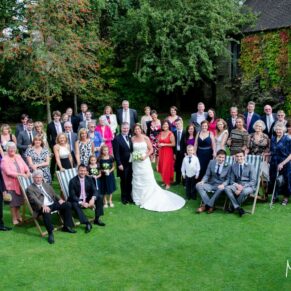 Photography of all the wedding guests as they gather in the wonderful gardens for a large group pose at the Bay Tree Hotel in Burford